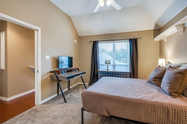 Carpeted bedroom with vaulted ceiling, baseboards, and a ceiling fan | Image 15