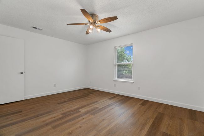 Unfurnished room featuring a ceiling fan, wood finished floors, and a textured ceiling | Image 23