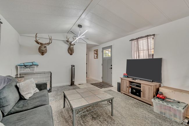 Living area with a notable chandelier and vaulted ceiling with beams | Image 6