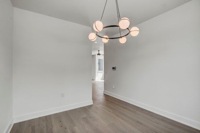 Unfurnished room with a chandelier, baseboards, and wood finished floors | Image 13