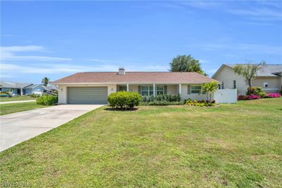 Single story home featuring a front yard and a garage | Image 1