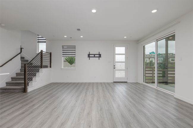 Unfurnished living room with light wood-style floors, stairs, and recessed lighting | Image 4
