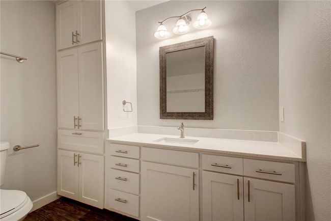 Bathroom featuring vanity, toilet, baseboards, and wood finished floors | Image 5