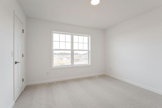 Photo is of the actual home. One of three generously sized secondary bedrooms with a spacious closet. | Image 13