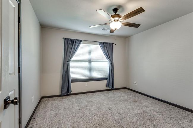 Unfurnished room with visible vents, baseboards, carpet flooring, and ceiling fan | Image 11