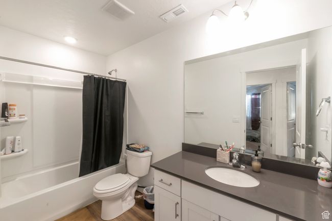 Bathroom with shower / bath combination with curtain, vanity, and wood finished floors | Image 11