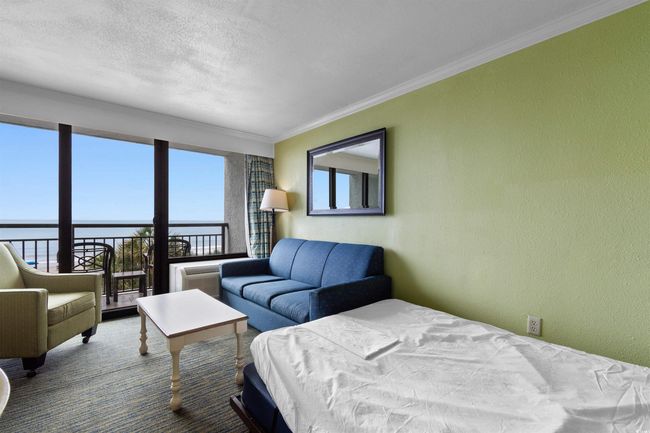 Bedroom featuring ornamental molding, a water view, a textured wall, and a textured ceiling | Image 10