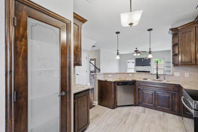 Kitchen featuring stainless steel appliances, a ceiling fan, a sink, tasteful backsplash, and dark brown cabinetry | Image 9