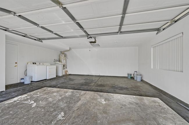 Garage with washing machine and dryer, a garage door opener, and strapped water heater | Image 19