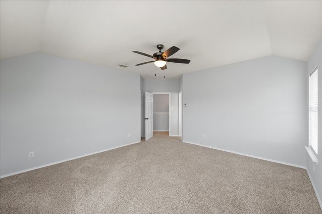 Unfurnished room featuring lofted ceiling, a ceiling fan, and light colored carpet | Image 24