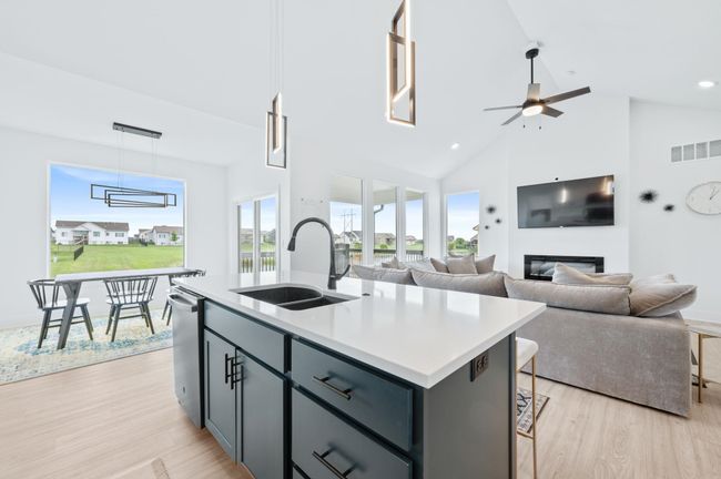 Kitchen with a sink, light wood-style floors, ceiling fan, a kitchen island with sink, and light countertops | Image 13