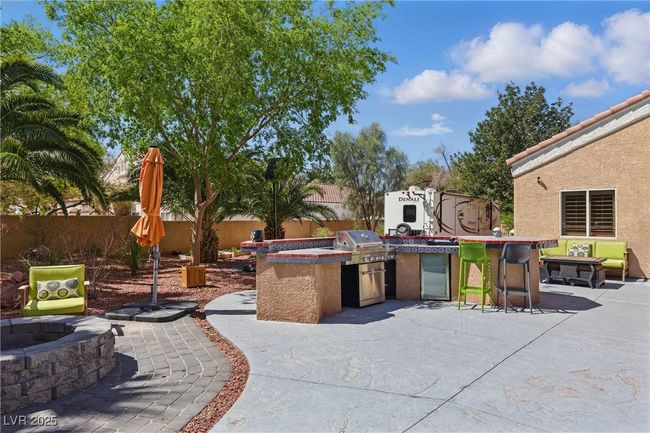 View of patio / terrace featuring a fire pit, grilling area, a fenced backyard, and area for grilling | Image 38