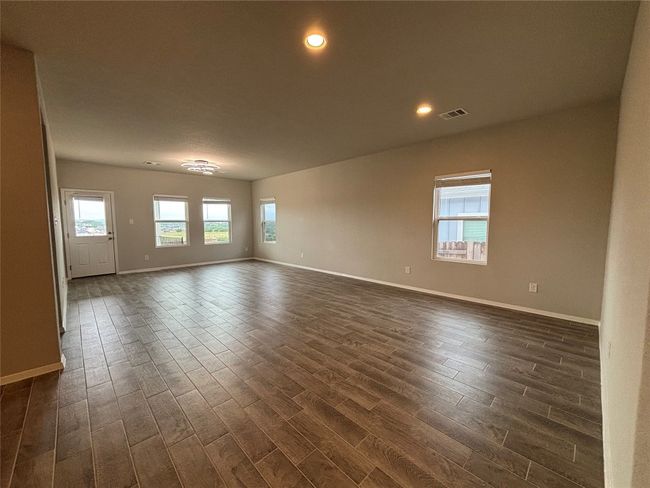 Unfurnished room with dark wood-type flooring, baseboards, and recessed lighting | Image 5