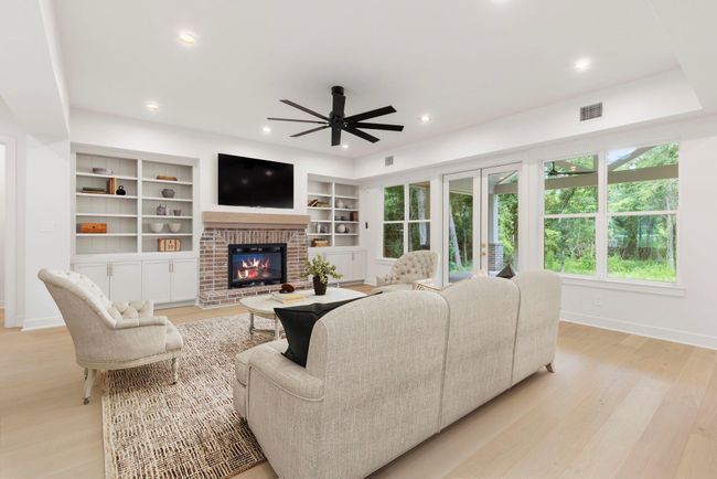 Beautiful brick fireplace with floating mantle and custom shelving and cabinetry provide a beautiful focal point. | Image 6