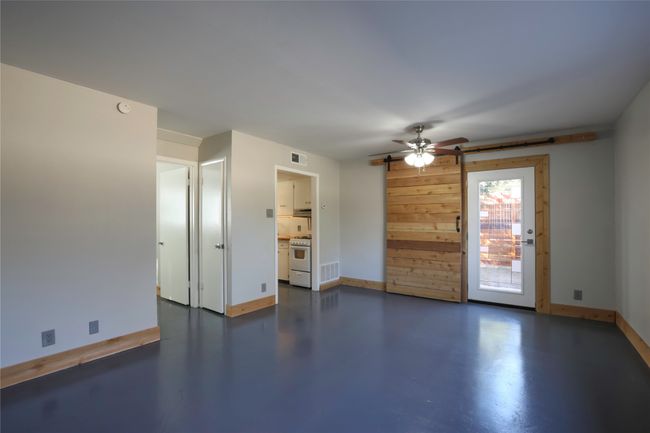 Empty room featuring finished concrete flooring, a ceiling fan, and a smoke detector | Image 4