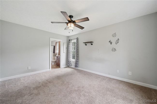 Carpeted spare room featuring a ceiling fan and baseboards | Image 7