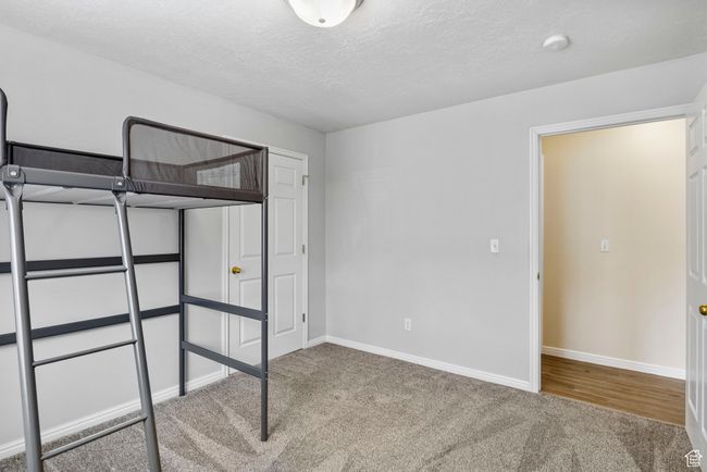 Unfurnished bedroom with carpet flooring, baseboards, and a textured ceiling | Image 15