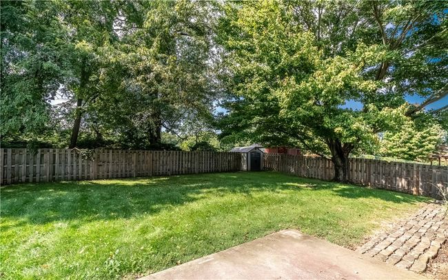 The home has a spacious, flat, and fenced-in backyard with a shed. | Image 24