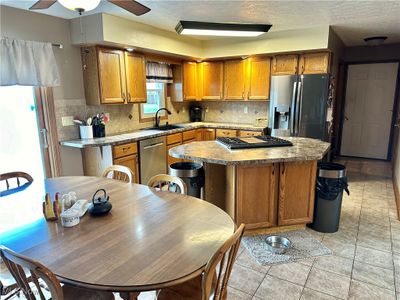 Kitchen with stainless steel appliances, tasteful backsplash, sink, a center island, and ceiling fan | Image 3