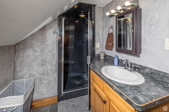 Bathroom featuring tile patterned floors, vanity, and vaulted ceiling | Image 29