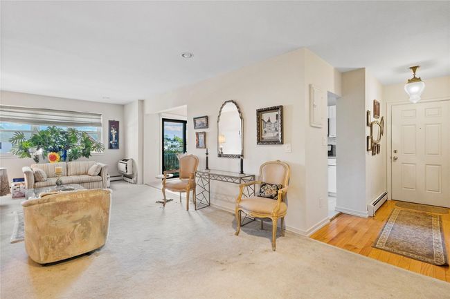 Living area with baseboard heating, baseboards, and light wood finished floors | Image 18