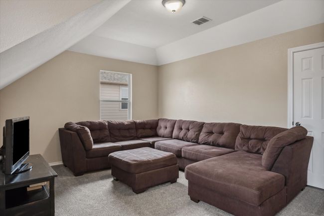 Living area featuring carpet floors, lofted ceiling, and visible vents | Image 26