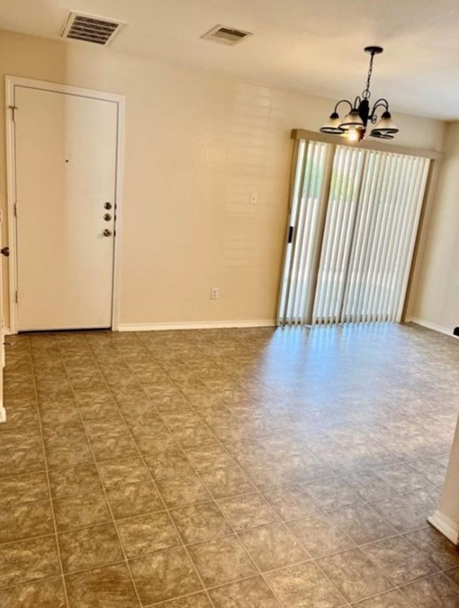 Spare room with a chandelier and baseboards | Image 4