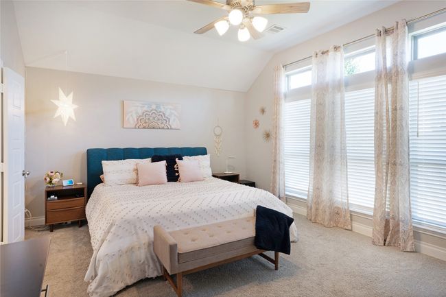 Bedroom with lofted ceiling, multiple windows, light colored carpet, and ceiling fan | Image 19