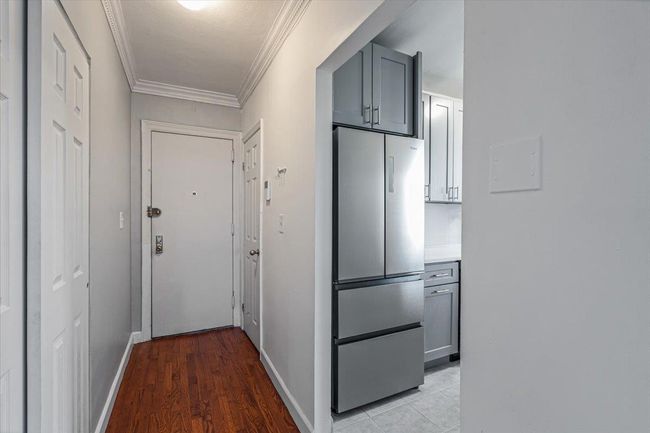 Hall featuring light wood-type flooring and crown molding | Image 7