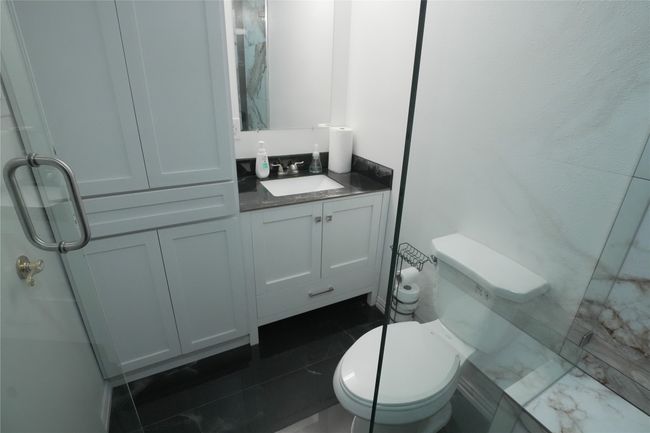 Full bath with toilet, vanity, and a marble finish shower | Image 10