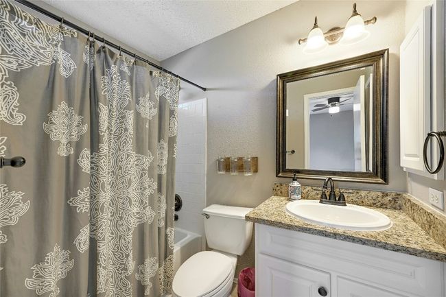 Full bathroom featuring vanity, a textured ceiling, and shower / tub combo with curtain | Image 25