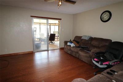 Living room featuring ceiling fan, wood-type flooring, and a textured ceiling | Image 3