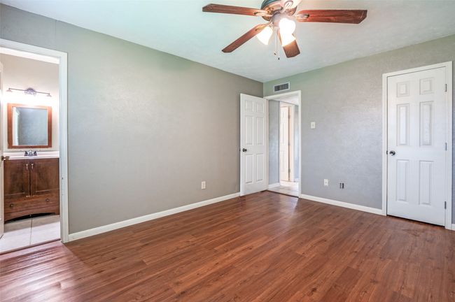 Unfurnished bedroom with wood finished floors, a ceiling fan, and ensuite bathroom | Image 15