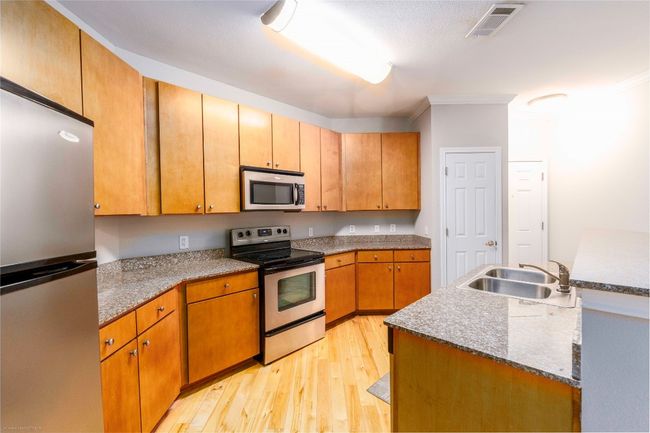 Kitchen featuring appliances with stainless steel finishes, light wood-style floors, and crown molding | Image 11