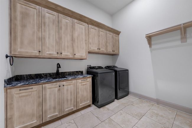 Washroom with cabinet space, light tile patterned flooring, and sink. | Image 30