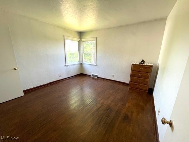 Bedroom with dark wood-style flooring and baseboards | Image 16