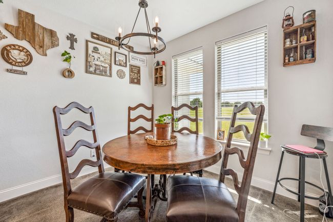 Carpeted dining space with baseboards and a chandelier | Image 10