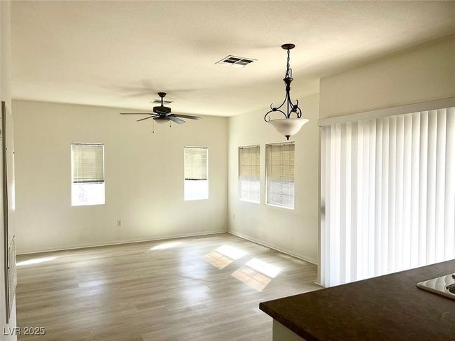 Unfurnished dining area with healthy amount of natural light, light wood-style floors, and ceiling fan | Image 7
