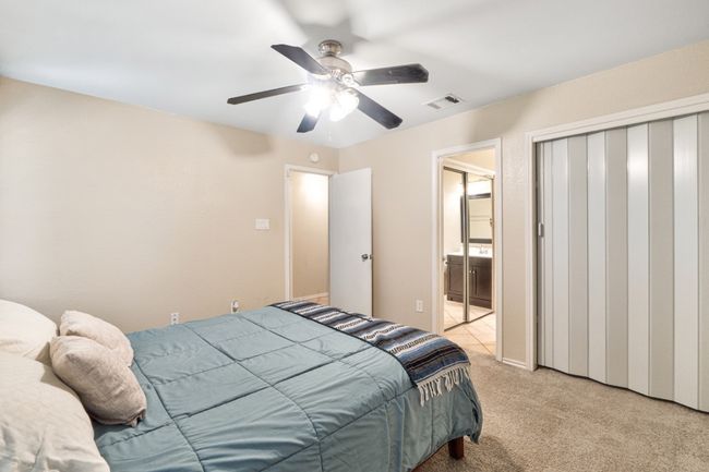 Primary bedroom offers a private retreat with ensuite and two closets and a ceiling fan. | Image 16