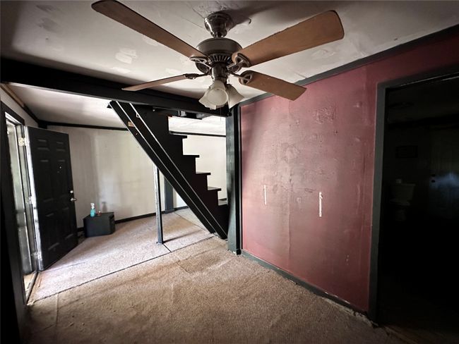 Finished basement with carpet floors, stairs, a ceiling fan, and baseboards | Image 21
