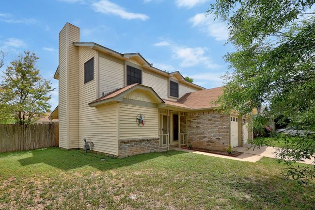 View of front of property featuring brick siding, an attached garage, fence, and a front yard | Image 29