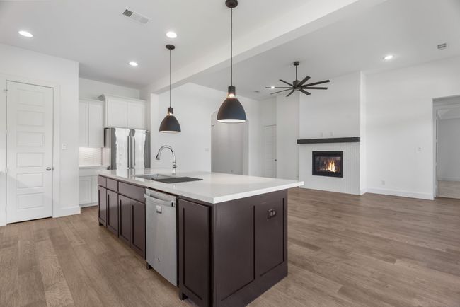 Kitchen with stainless steel appliances, a sink, light wood-style flooring, light countertops, and white cabinets | Image 30