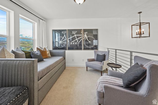 Carpeted living area with a chandelier and baseboards | Image 20