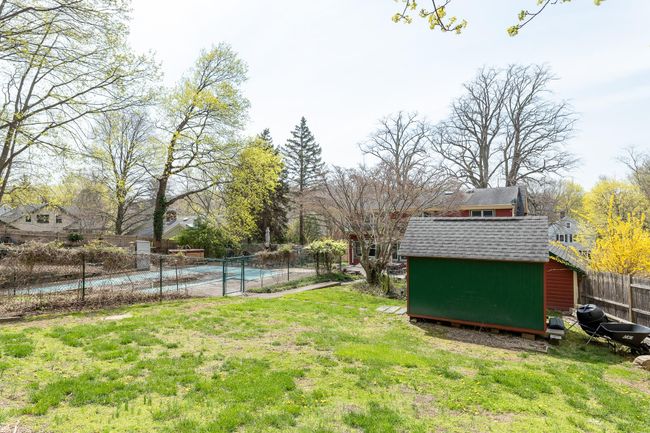 View of yard featuring a storage unit, a fenced in pool, an outbuilding, and fence | Image 4