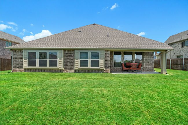 Back of house featuring brick siding, a patio area, and roof with shingles | Image 26