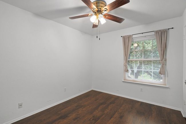Empty room with dark wood-style flooring and ceiling fan | Image 27