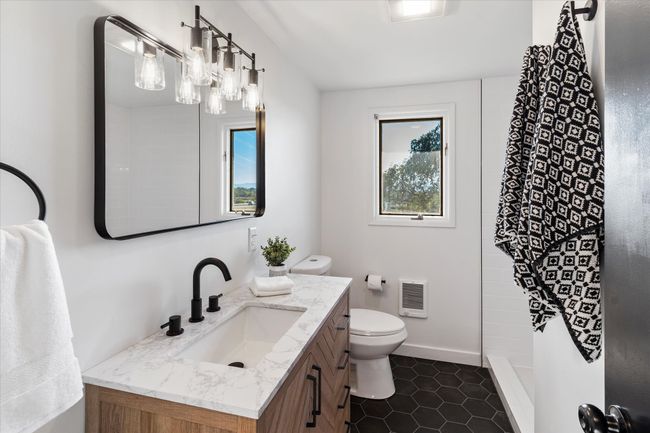 Bathroom featuring vanity, heating unit, a shower, tile patterned floors, and toilet | Image 29