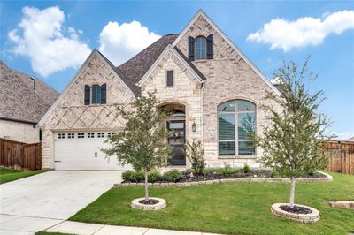 You will love this home the minute you arrive! The attractive brick and stone exterior is enhanced with stone edging on the flower beds and nice landscaping. | Image 1