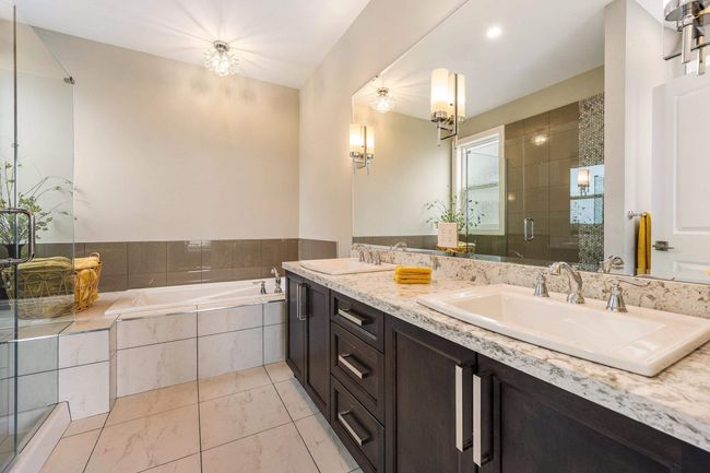 Bathroom with double vanity, a sink, a stall shower, and a bath | Image 23