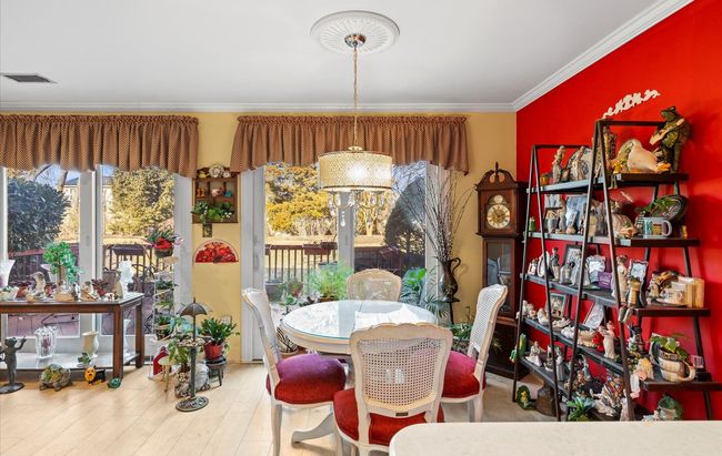 Dining area with visible vents, wood finished floors, and crown molding | Image 5